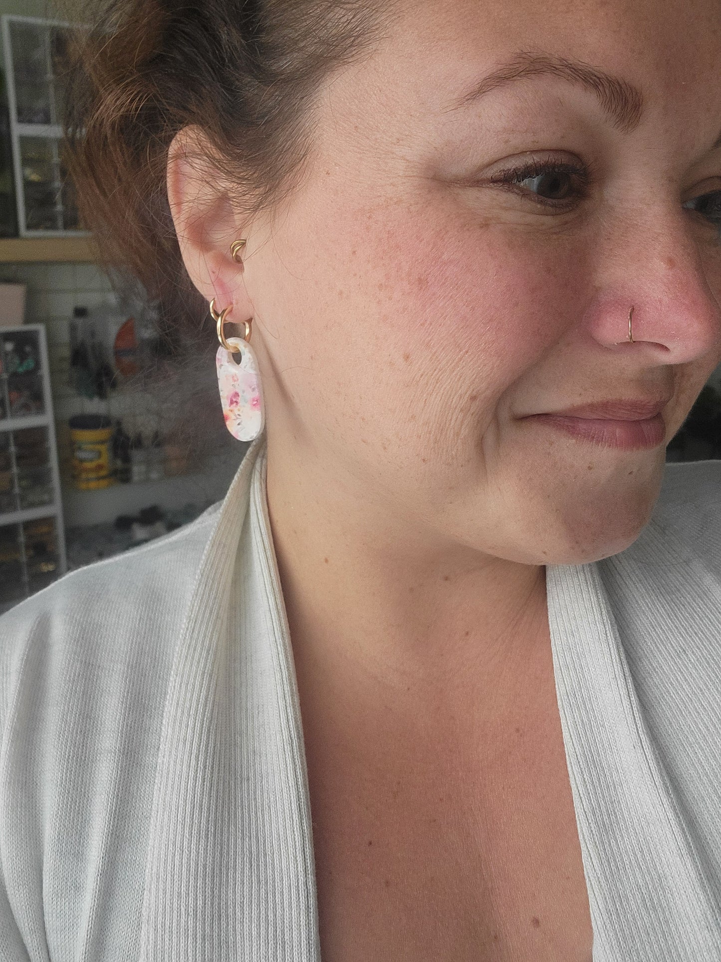 Close-up of a person wearing earrings with a blurred background