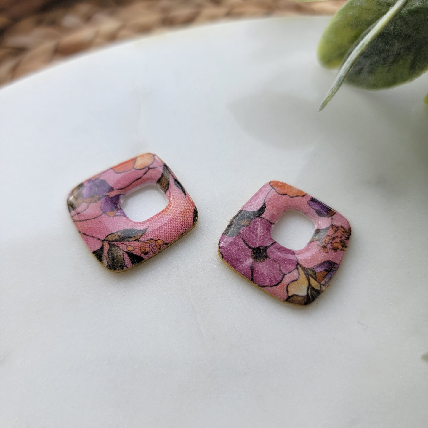 Pair of floral-patterned earrings on a light background