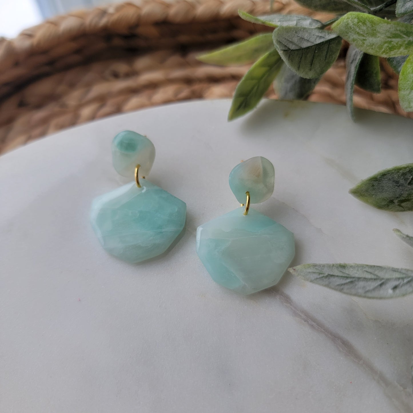 Light blue earrings on a light surface.