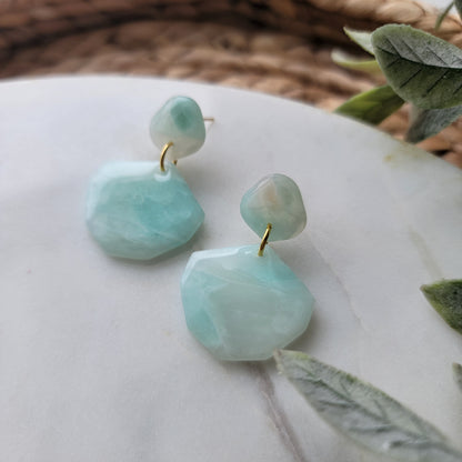Light blue stone designed earrings on a light surface. 