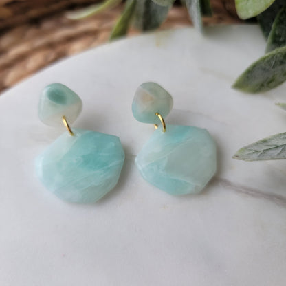 Light blue stone designed earrings on a light background.
