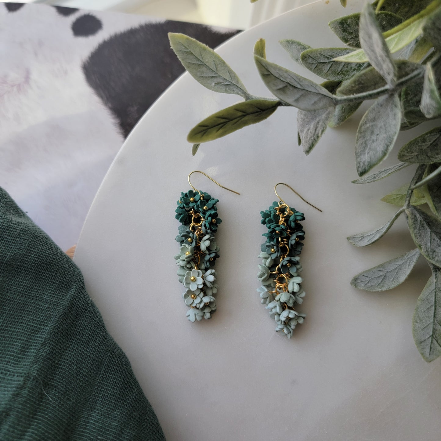 Green floral earrings on a white background
