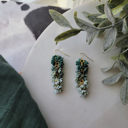Green floral earrings on a white background